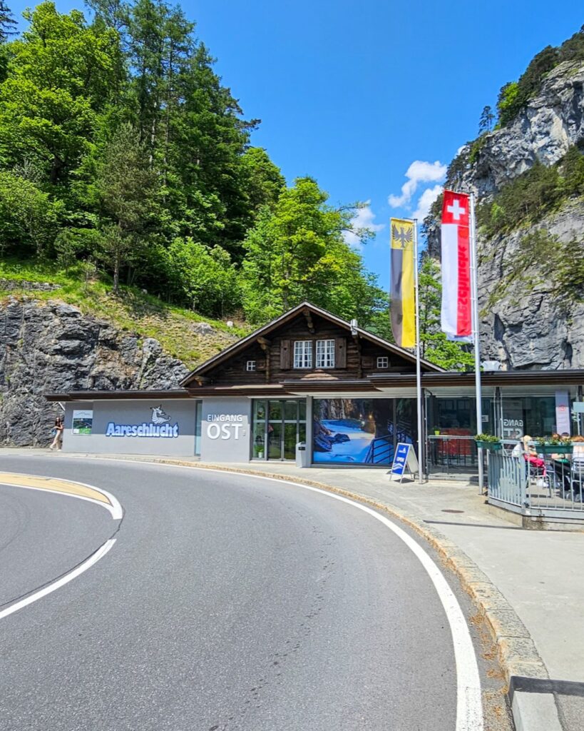 East entrance building of the Aare Gorge by the road, with a Swiss flag