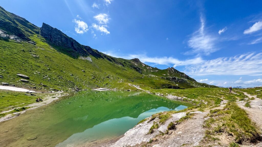 Baschalvasee, a green lake beside the trail on a sunny day
