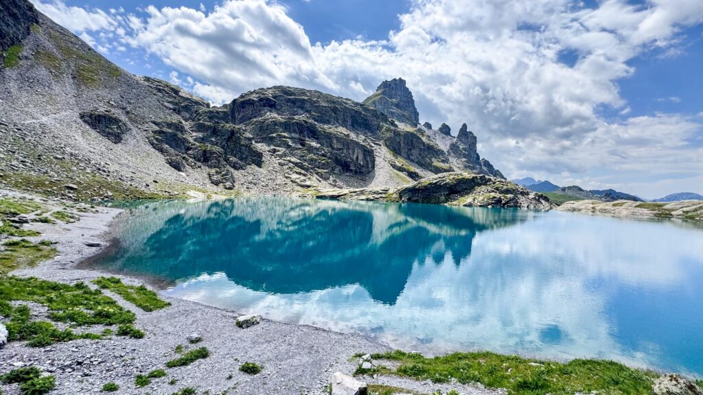 Schottensee reflecting the surrounding peaks and clouds